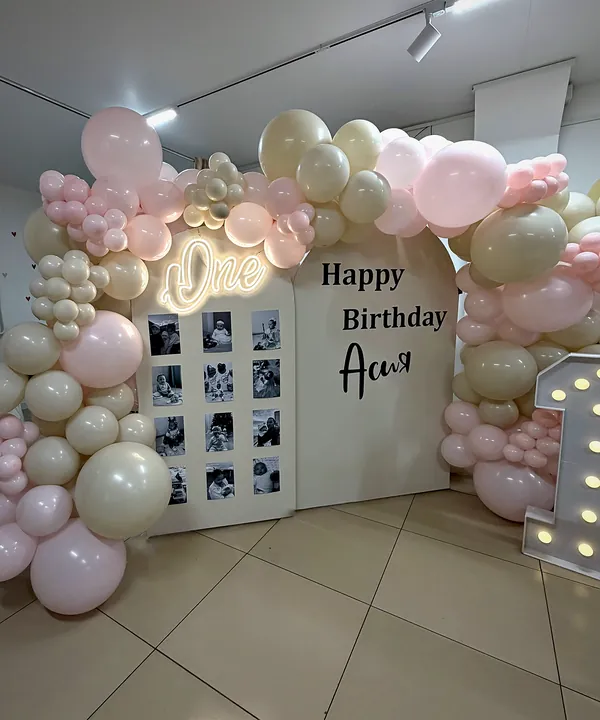 Фотостена с детскими снимками, неоновая надпись «One», «Happy Birthday Ася», светящаяся цифра 1 и арка из розовых и кремовых шаров