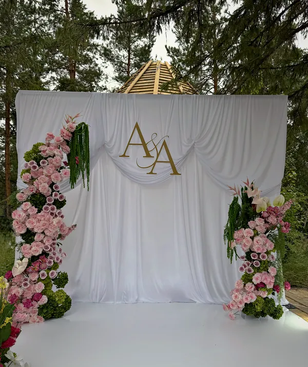 Выездная регистрация: белый задник с монограммой A&A и колонны из розовых роз в сосновом лесу